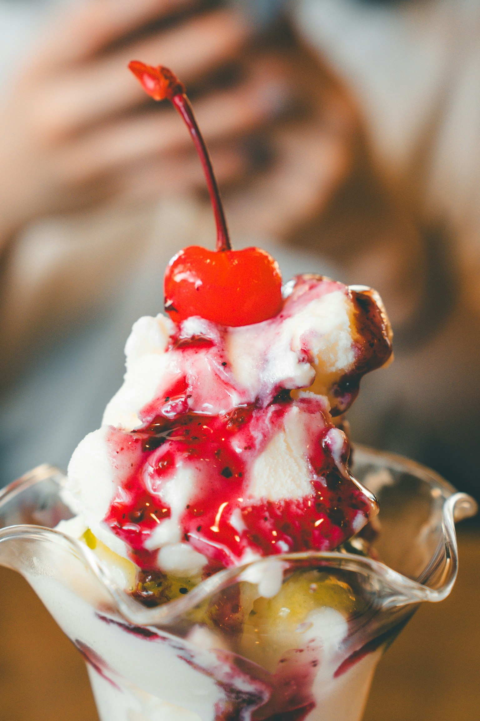 Ice cream dessert topped with cream and a cherry