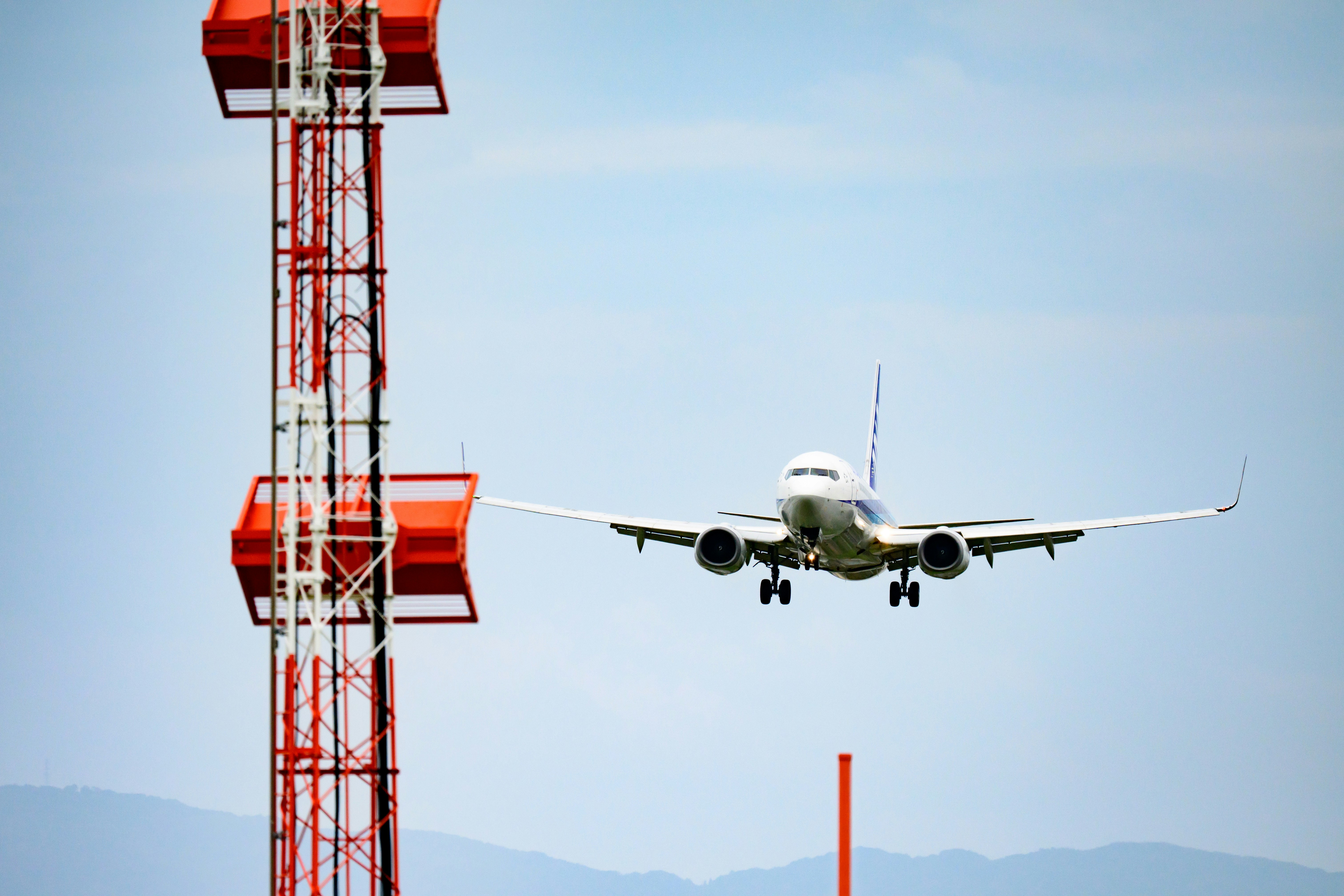 avión pasando junto a una torre de comunicaciones en el cielo