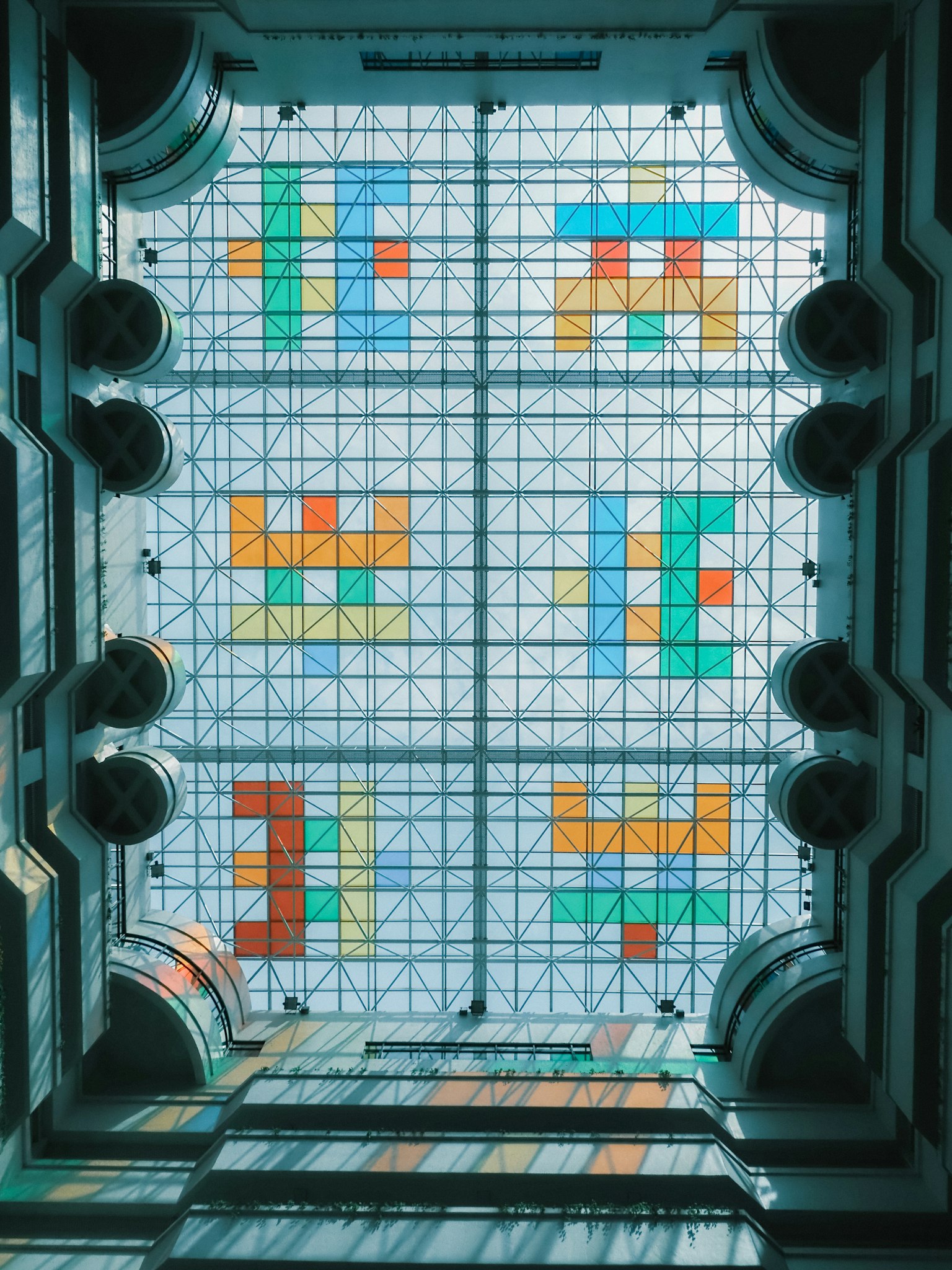 Pandangan ke atas langit-langit mozaik berwarna-warni dengan pola geometris
