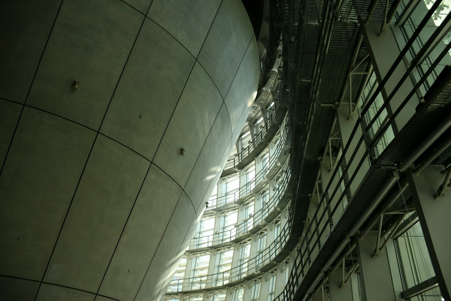 Innenraum einer modernen Architektur mit gewellter Betonwand und Glasstruktur