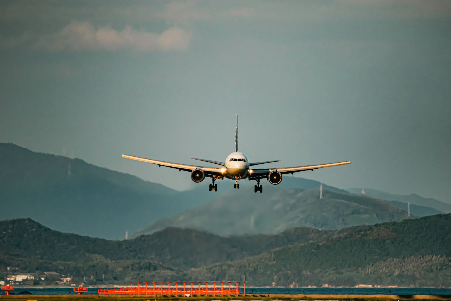 Aereo passeggeri in atterraggio con montagne sullo sfondo