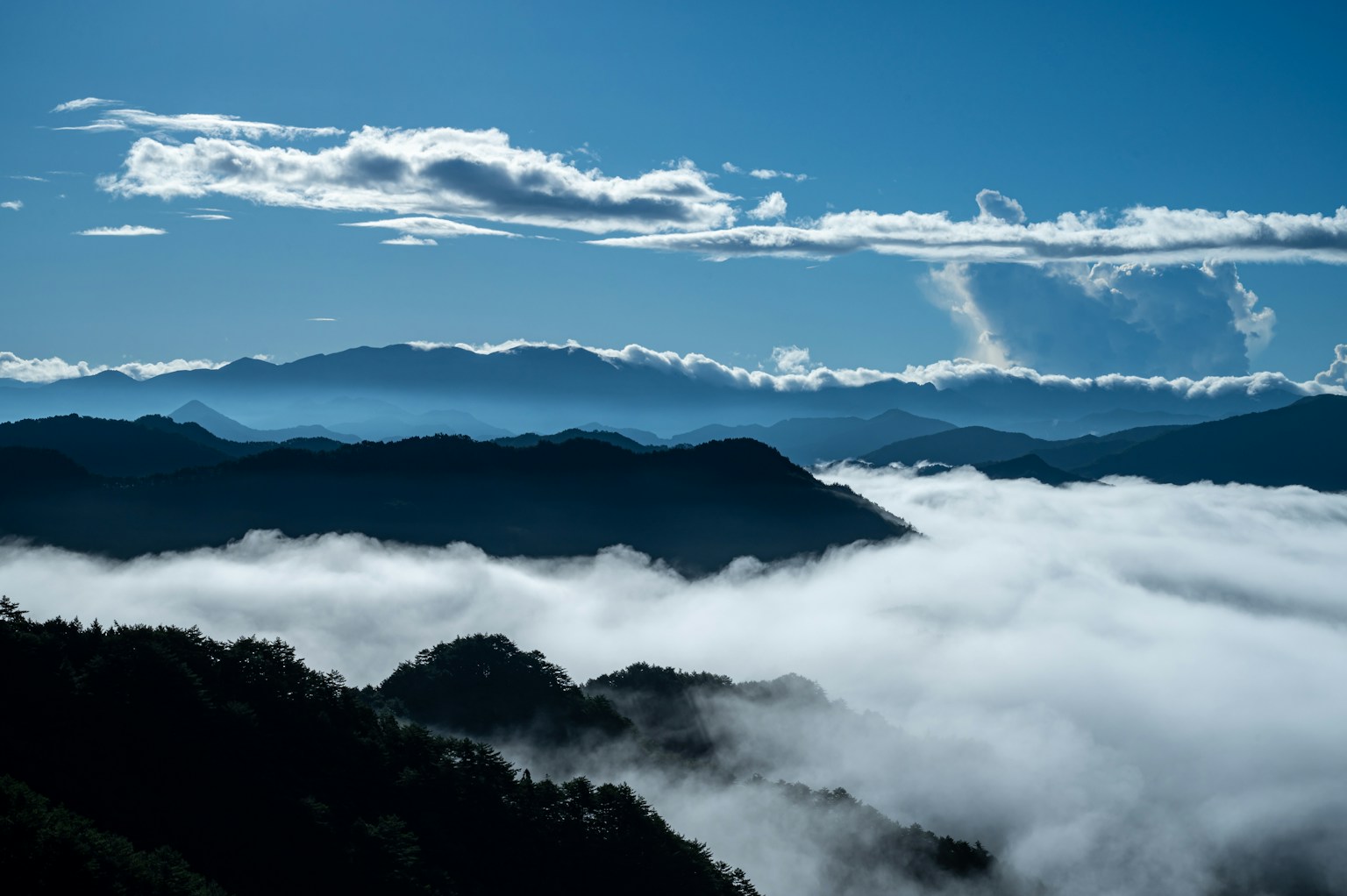 青空と雲に覆われた山々の風景