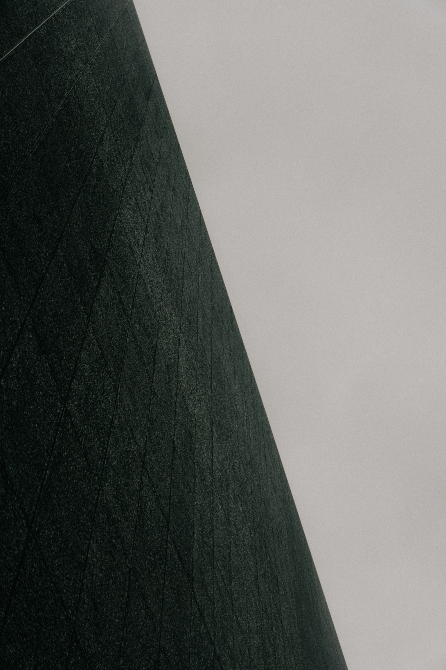 Diagonal dark green surface with gray sky