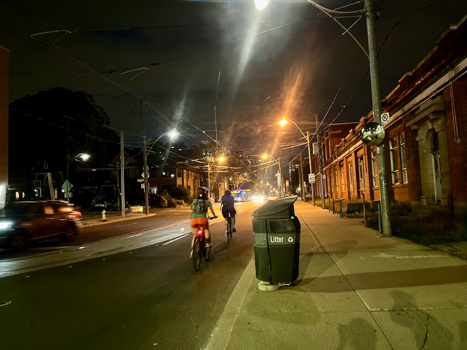 Radfahrer fahren nachts auf einer Straße, die von Straßenlaternen beleuchtet wird