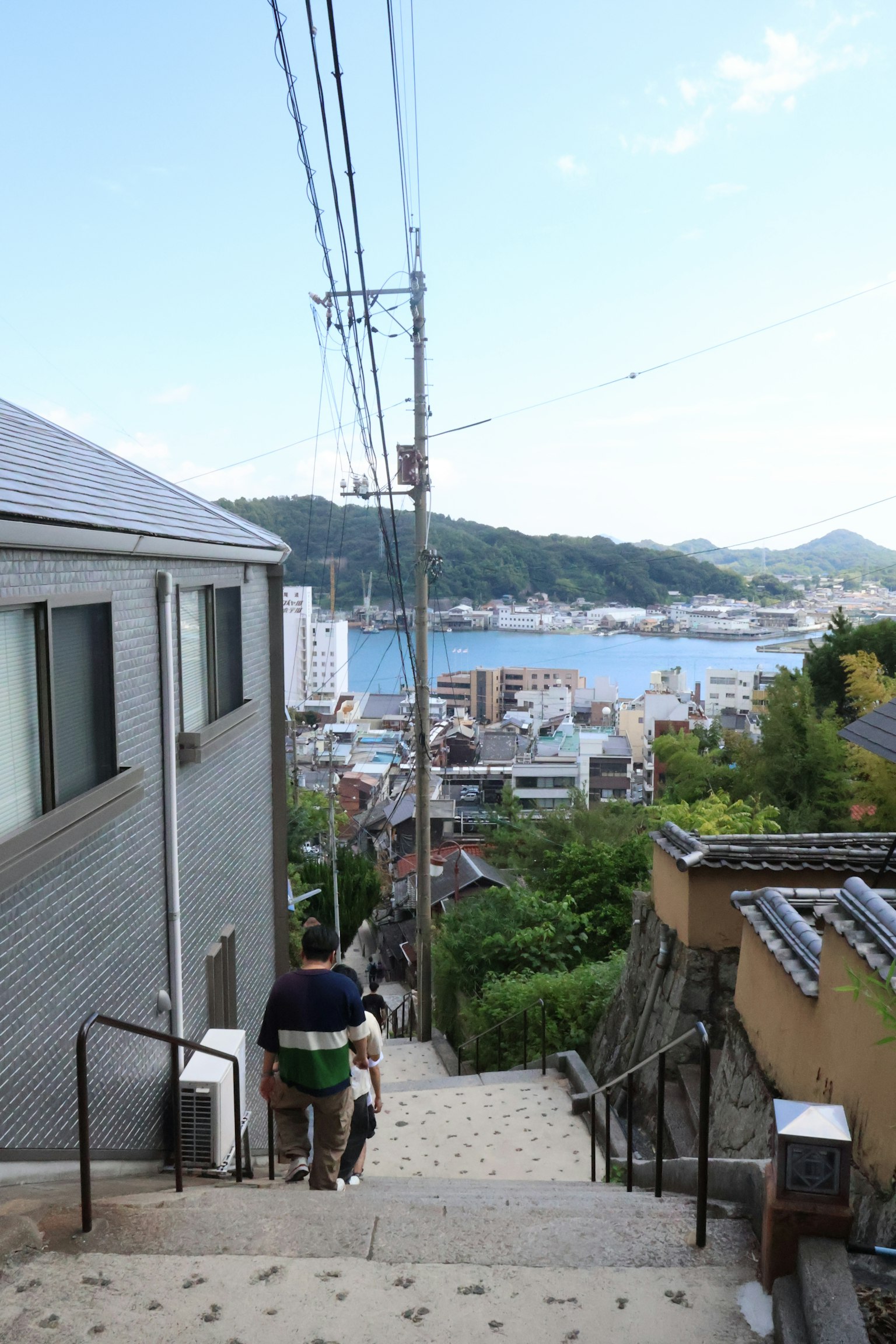 兩個人走下樓梯，俯瞰海洋和周圍的房屋