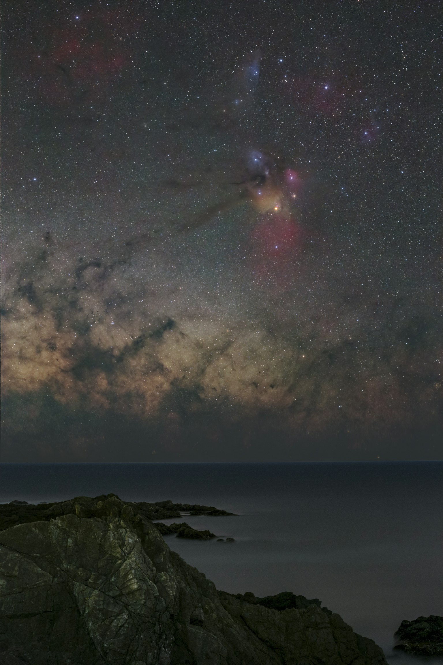 Paisaje marino con costa rocosa bajo un cielo estrellado