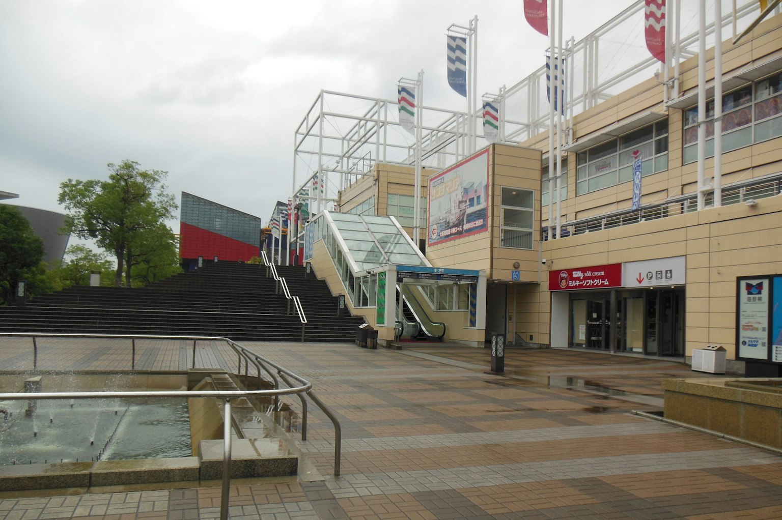 Modern shopping center exterior with stairs and storefronts