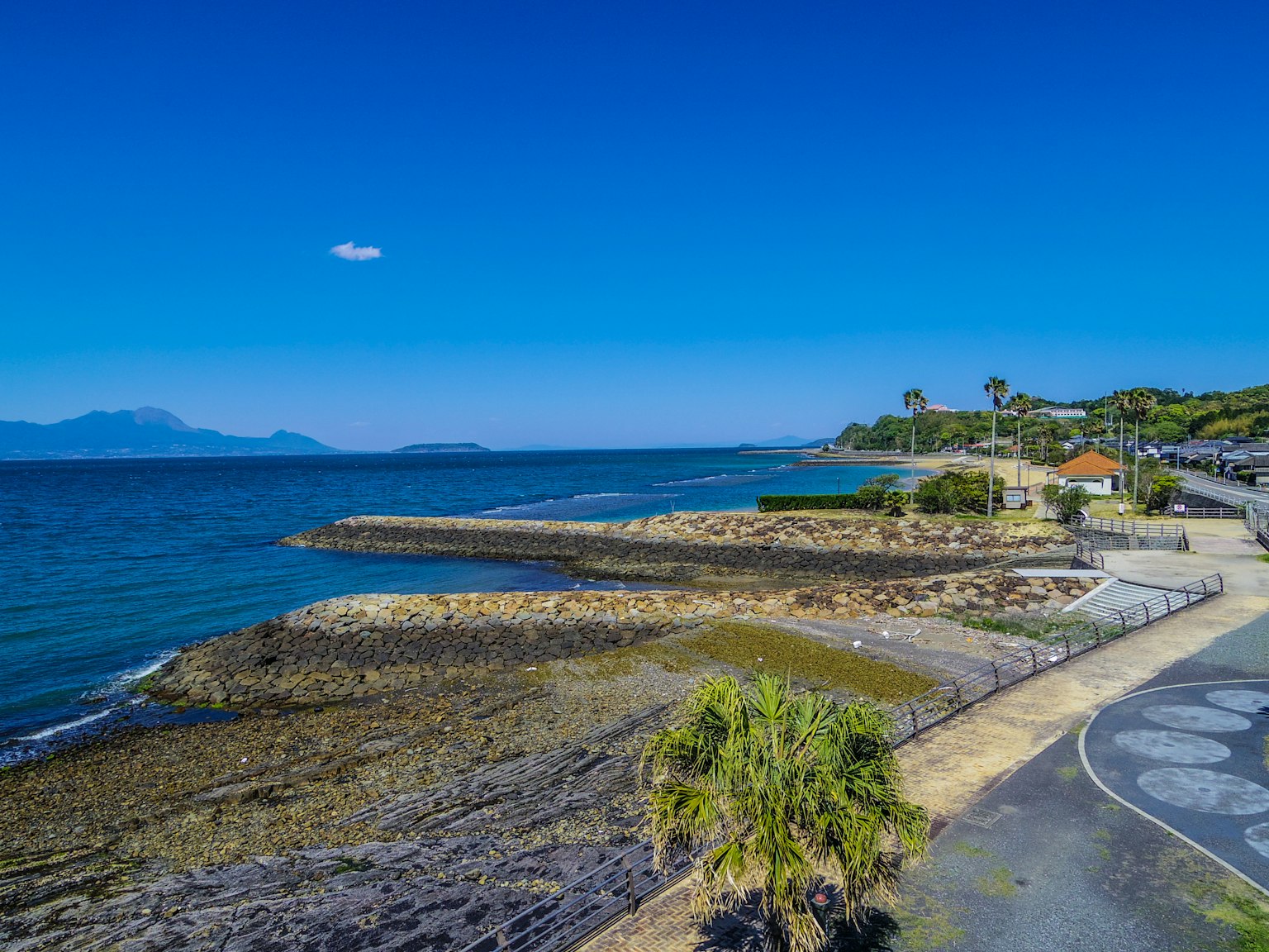 Vista panoramica dell'oceano blu e del cielo con una spiaggia e una strada