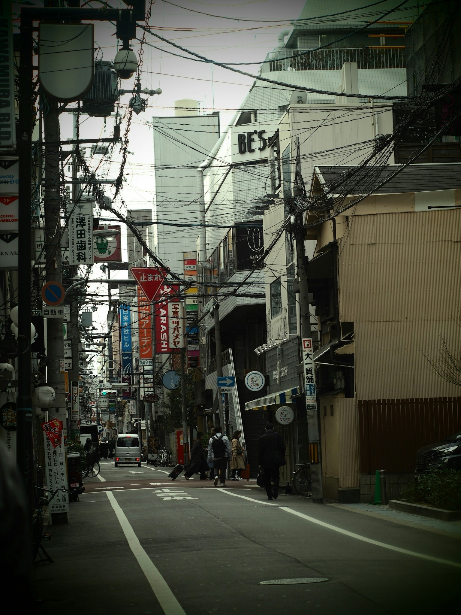 ทัศนียภาพถนนในเมืองที่มีร้านค้าและป้ายตามถนนแคบ