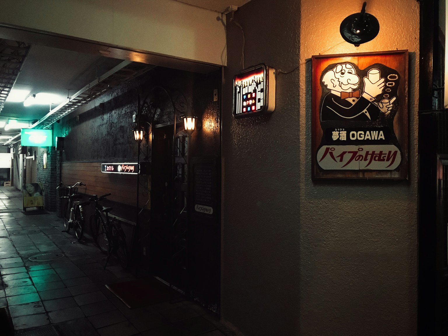 Insegna e illuminazione di un izakaya in una strada poco illuminata