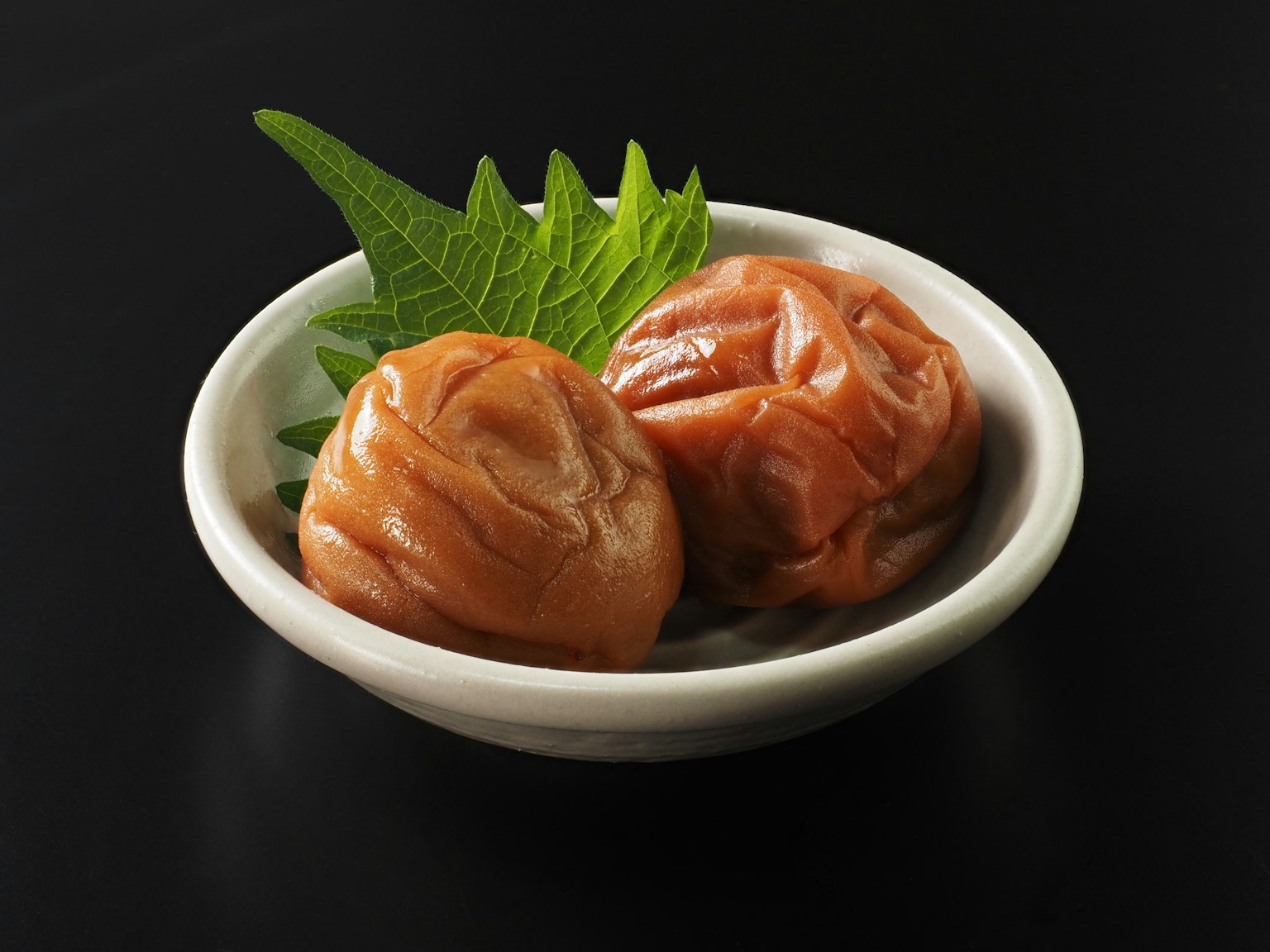 小碗中的腌梅子和紫苏叶