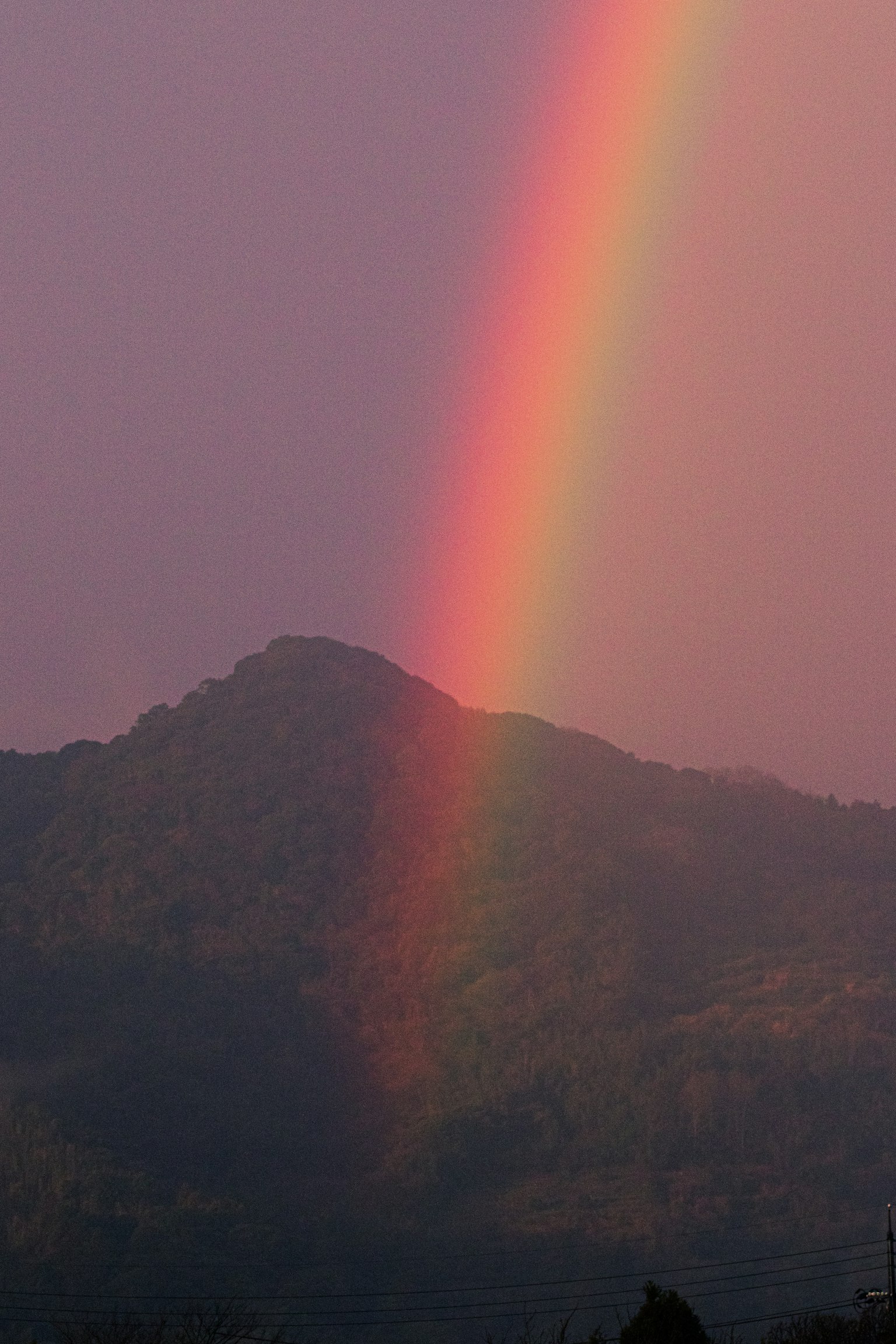 Vibrant rainbow arching over a misty mountain