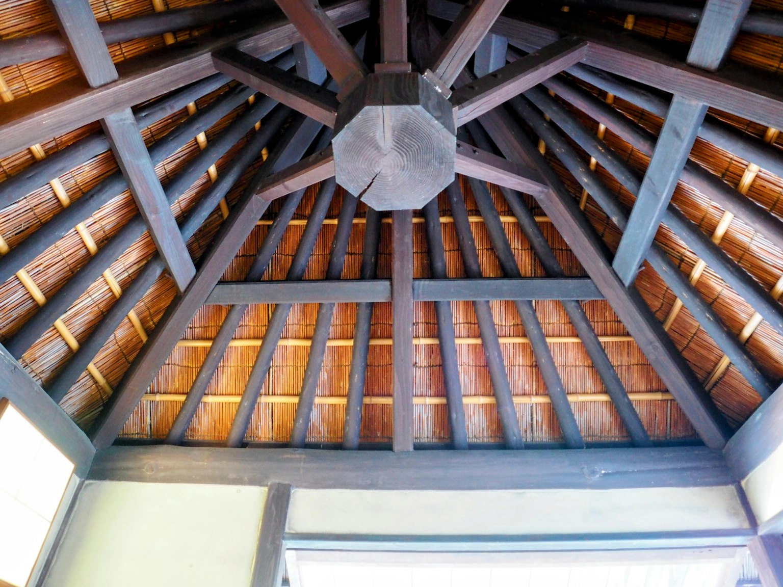 Interior view of a wooden ceiling with beams and striped design
