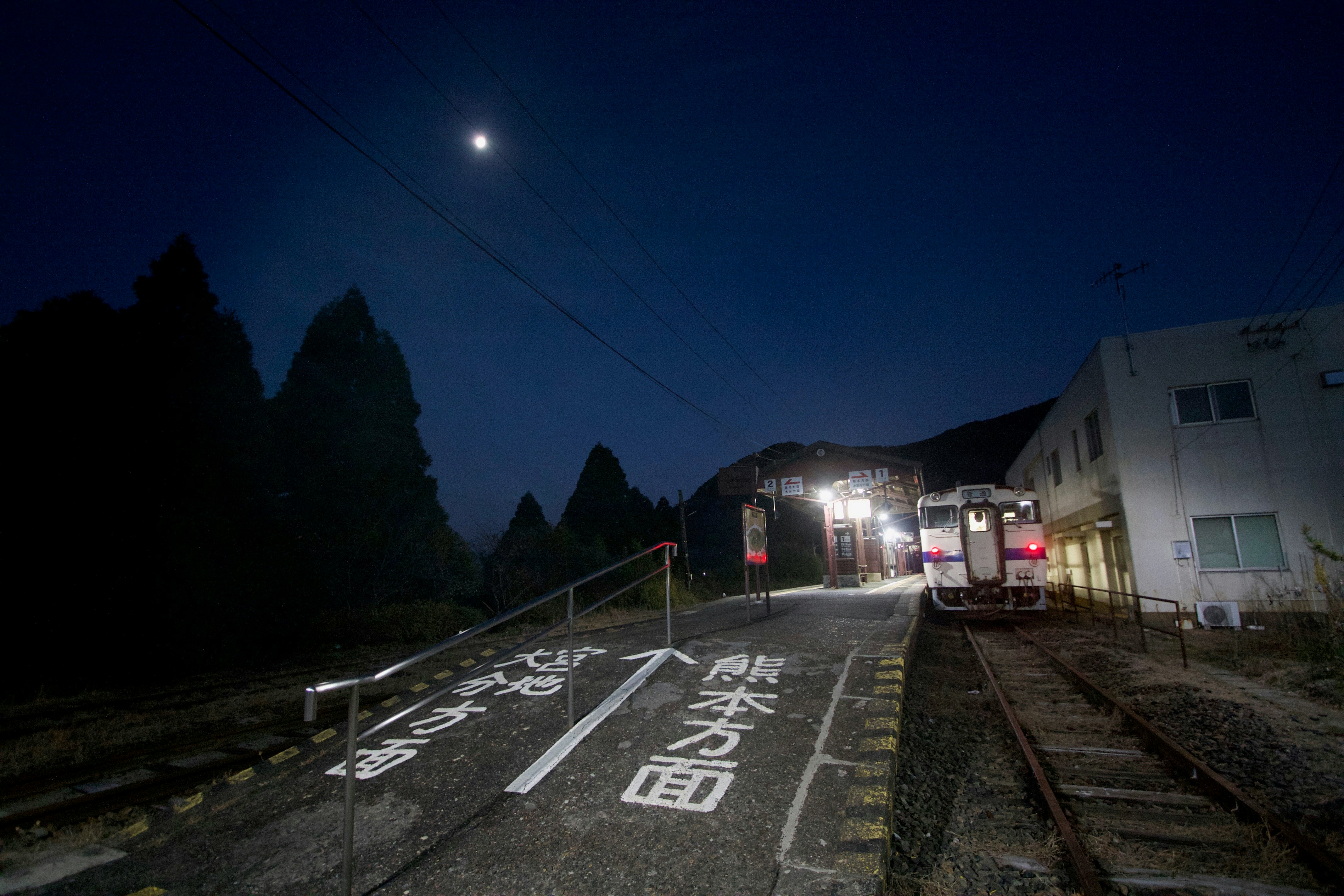 夜の踏切で線路と街灯が照らす風景