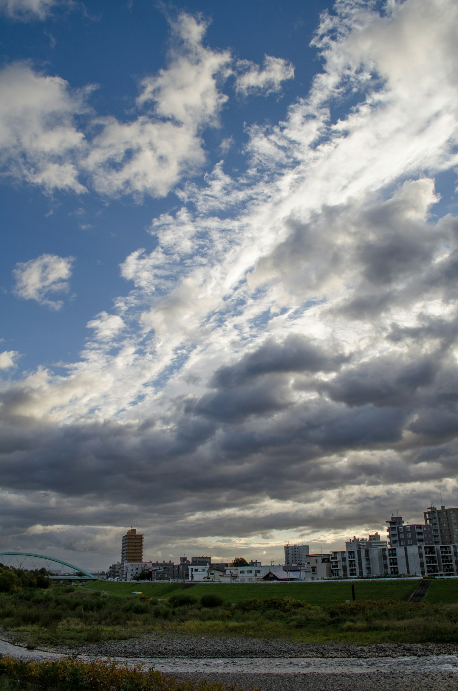 Vista escénica de un cielo azul con nubes y edificios al fondo