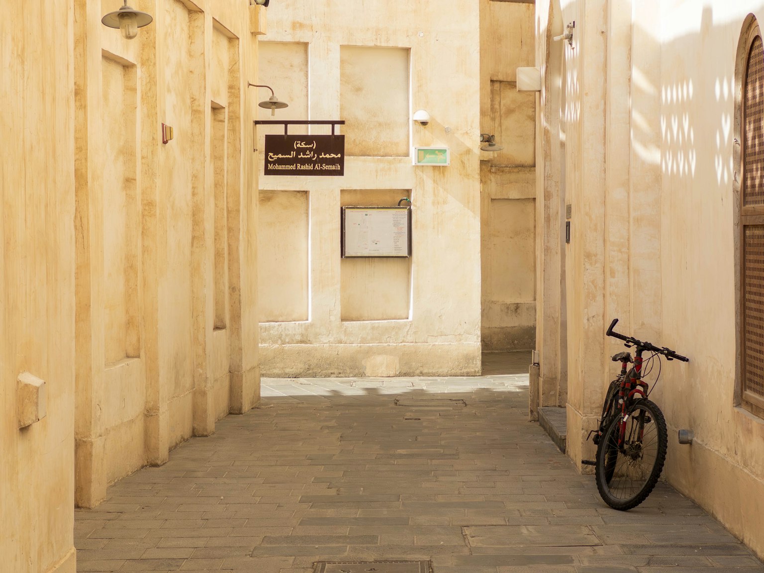 Schmale Gasse mit einem geparkten Fahrrad und hellen Gebäuden