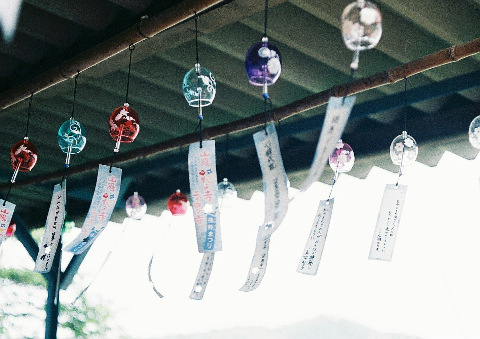 Clochettes et bandes de papier colorées suspendues sous un toit
