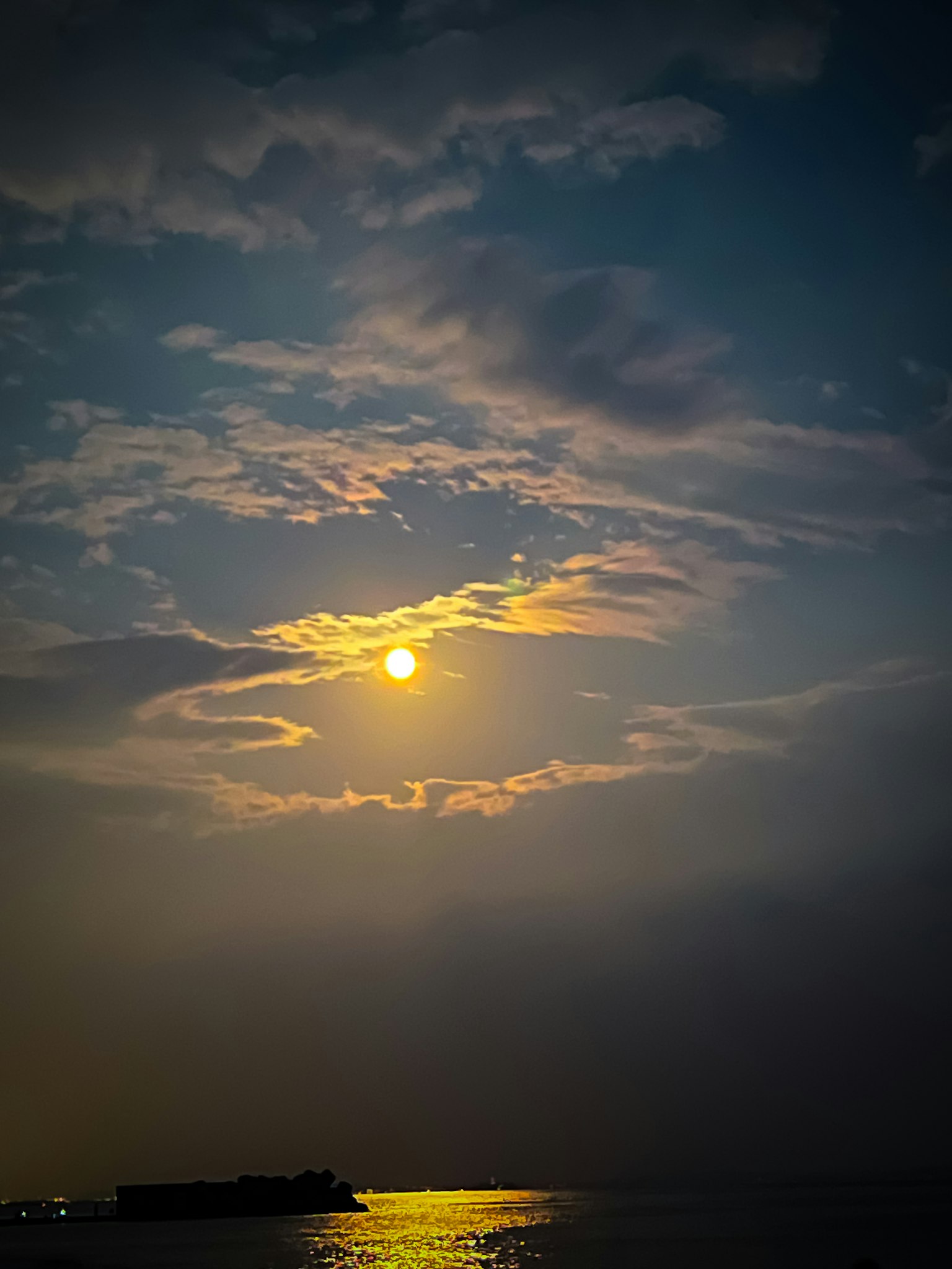 Tramonto sull'oceano con nuvole e riflessi