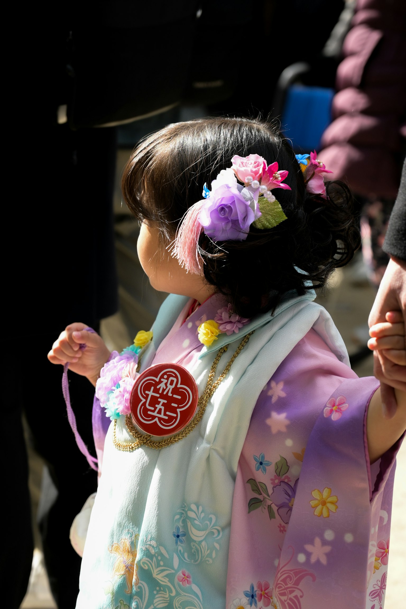 色とりどりの花飾りをつけた子供が着物を着ている様子