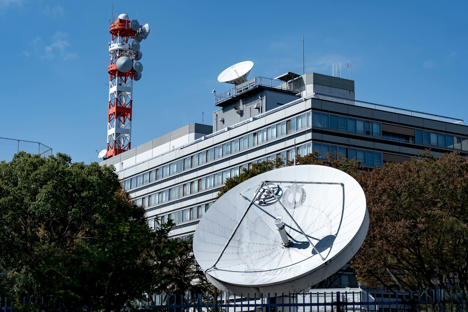 Esterno di un edificio con antenna satellitare e torre di comunicazione