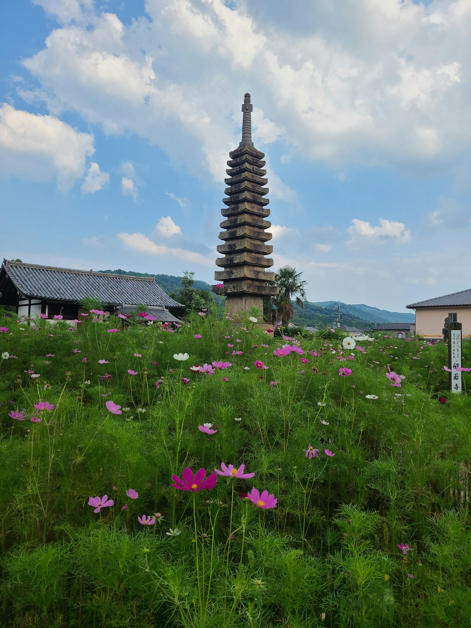 Eine alte Pagode umgeben von schönen Blumen unter einem blauen Himmel