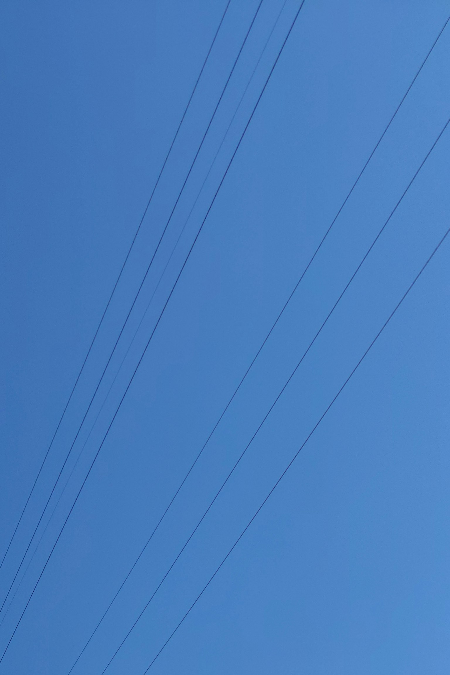 Silhouette di linee elettriche contro un cielo blu