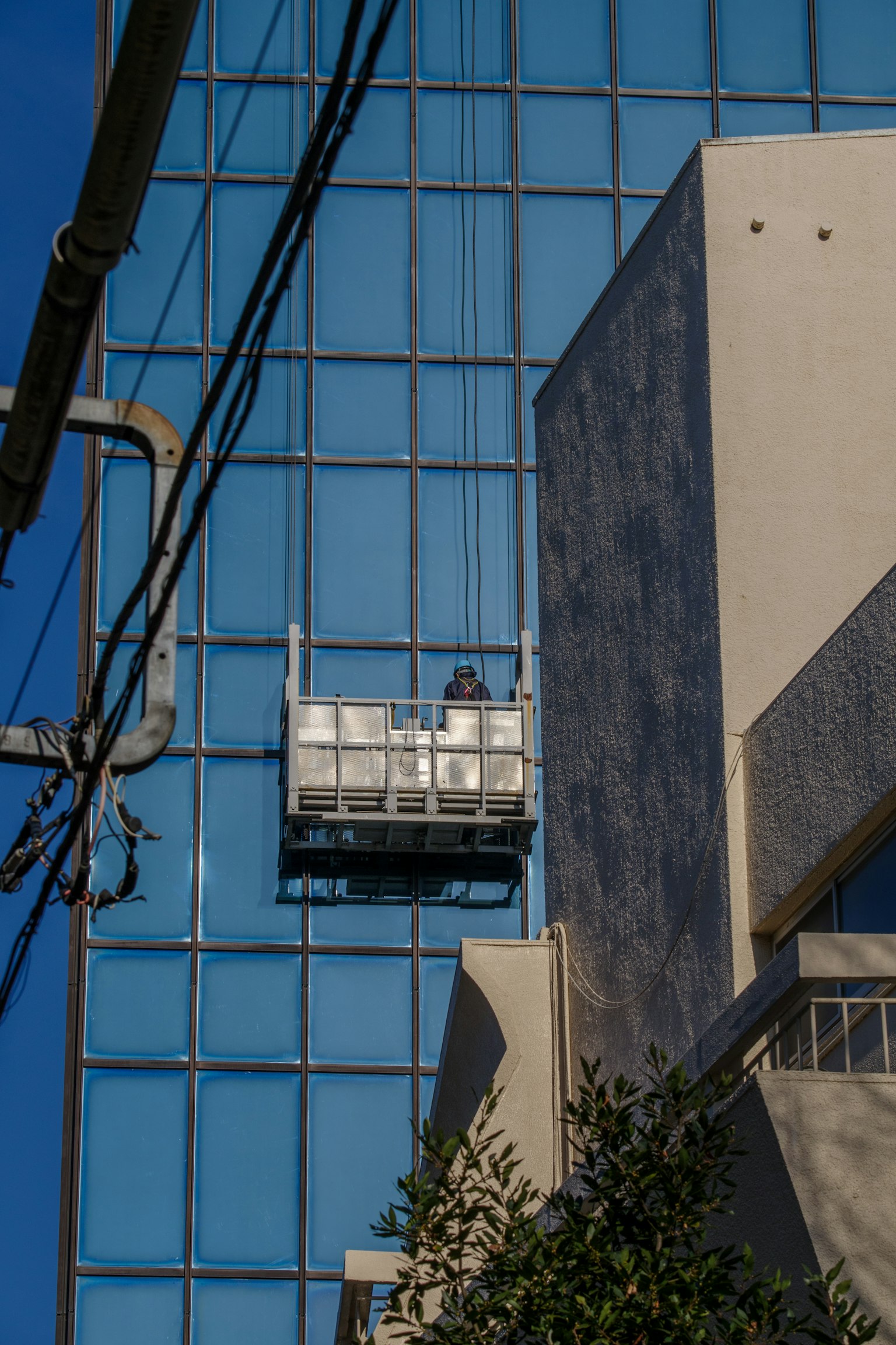 在藍色玻璃建築上清潔的工人