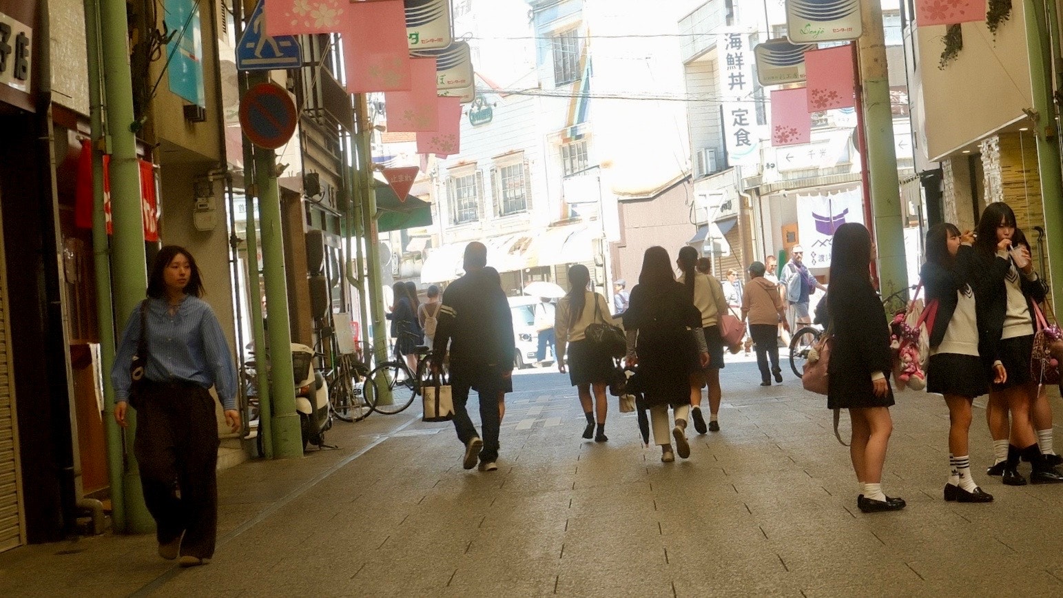 路地の商店街を歩く人々のにぎやかな通り