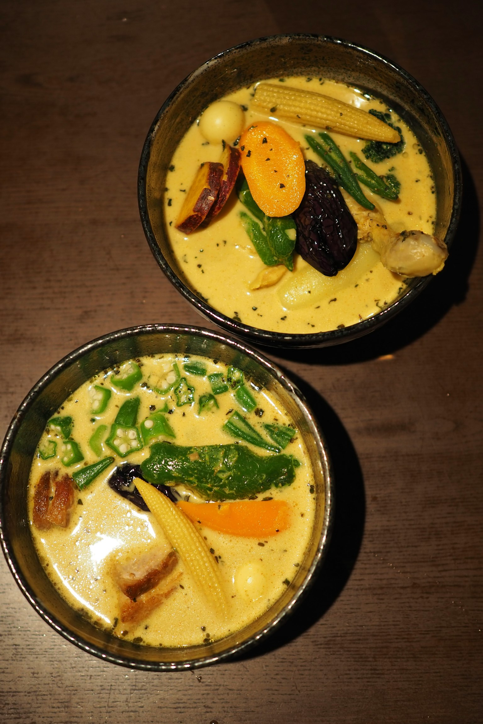 Due ciotole di zuppa al curry con verdure colorate