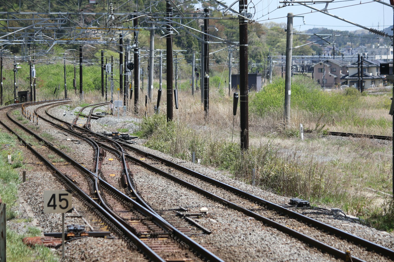 Scène d'un embranchement ferroviaire avec des voies courbes et de l'herbe