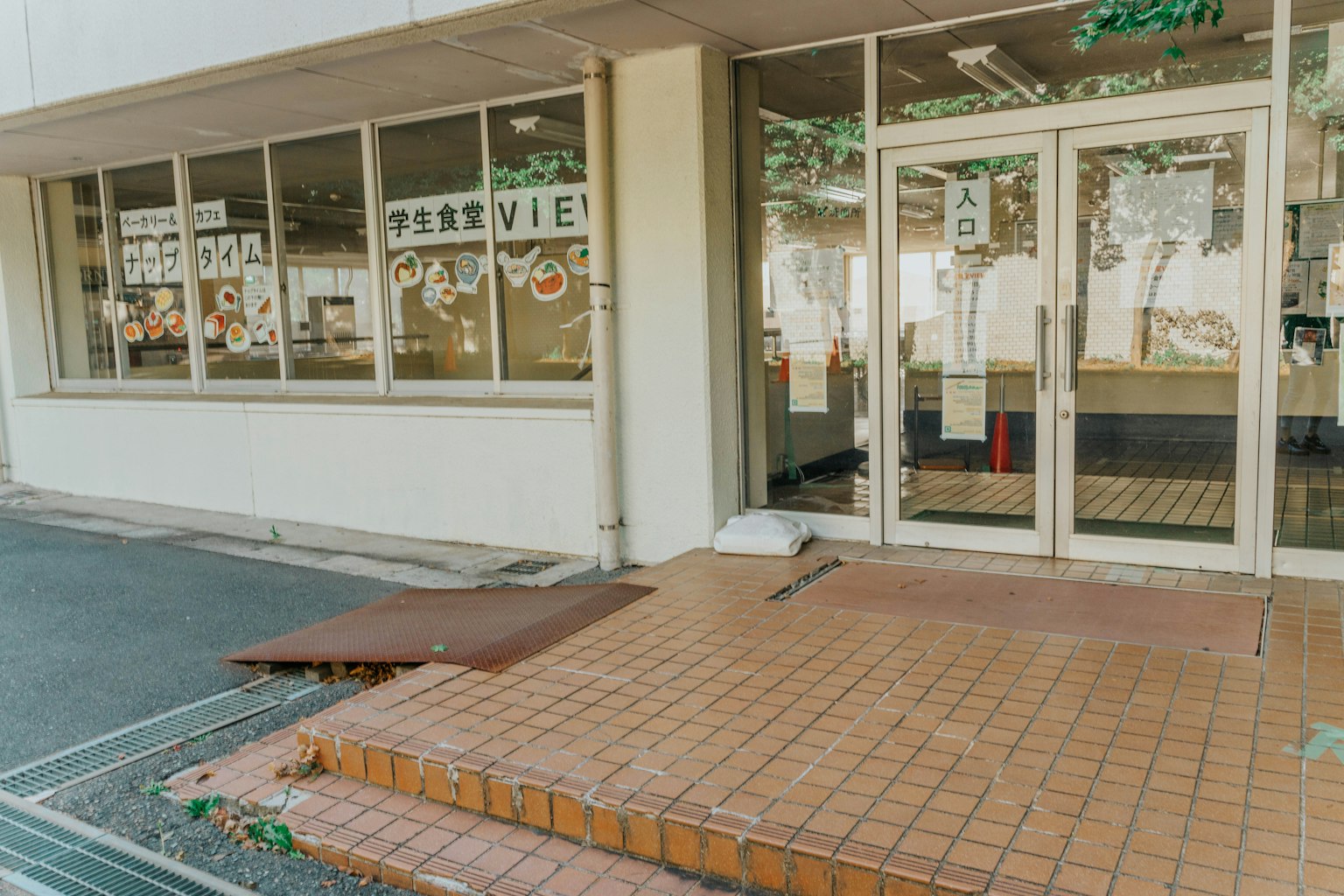 Entrance of a building with glass doors and tiled steps