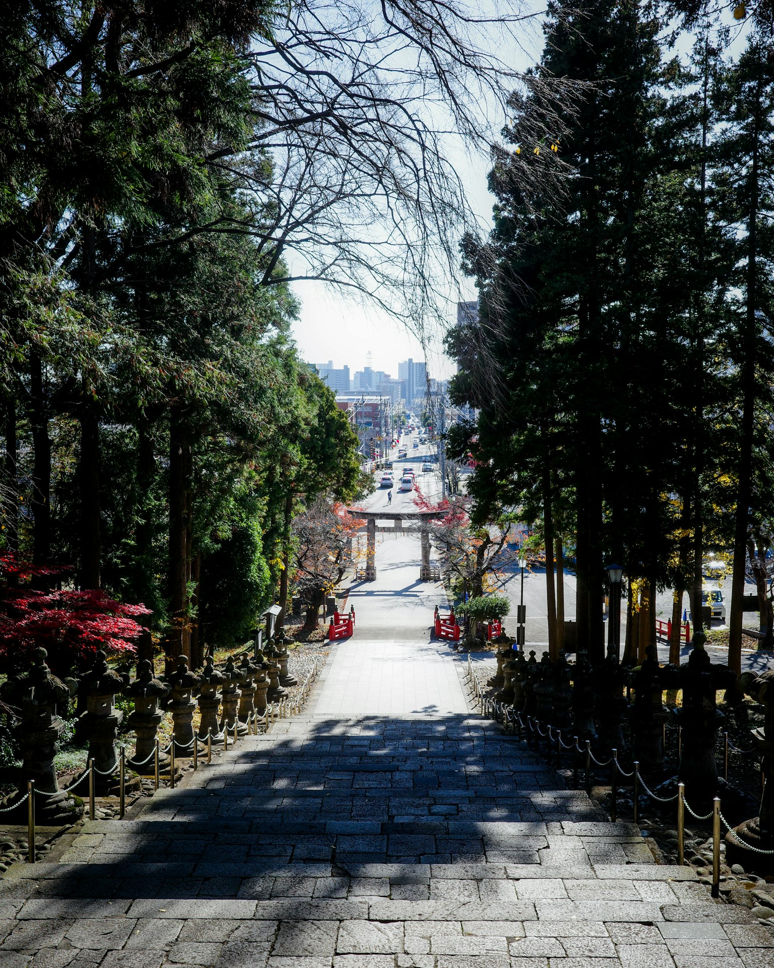 Escaleras de piedra que conducen a una vista de la ciudad a lo lejos rodeada de árboles verdes