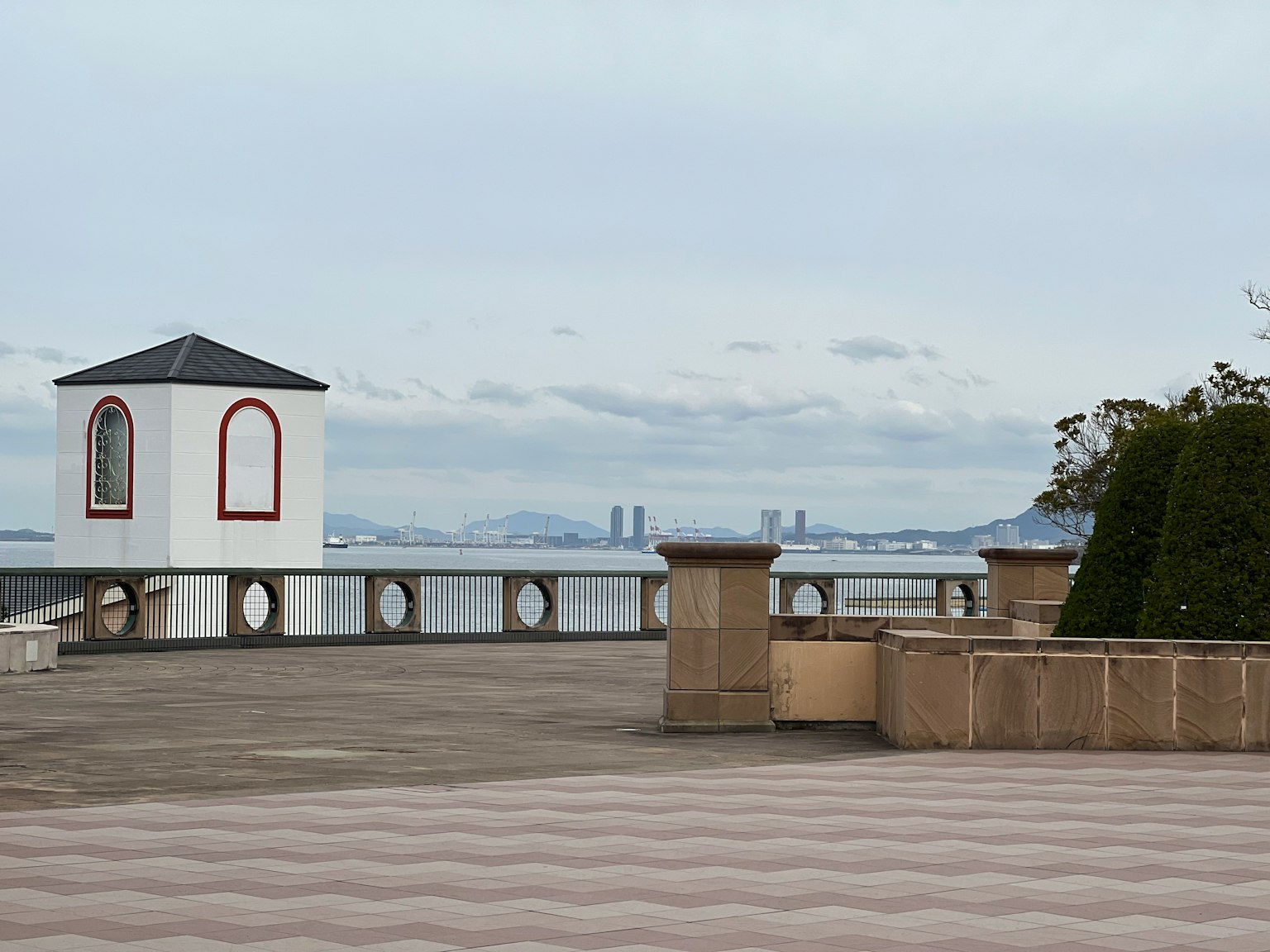 Terrazza con gazebo bianco che si affaccia sul mare e siepi verdi