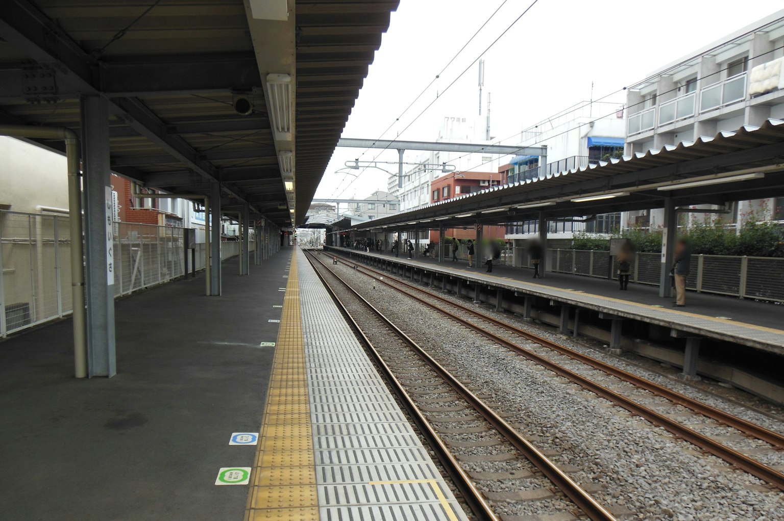 Quiet train station platform with visible railway tracks