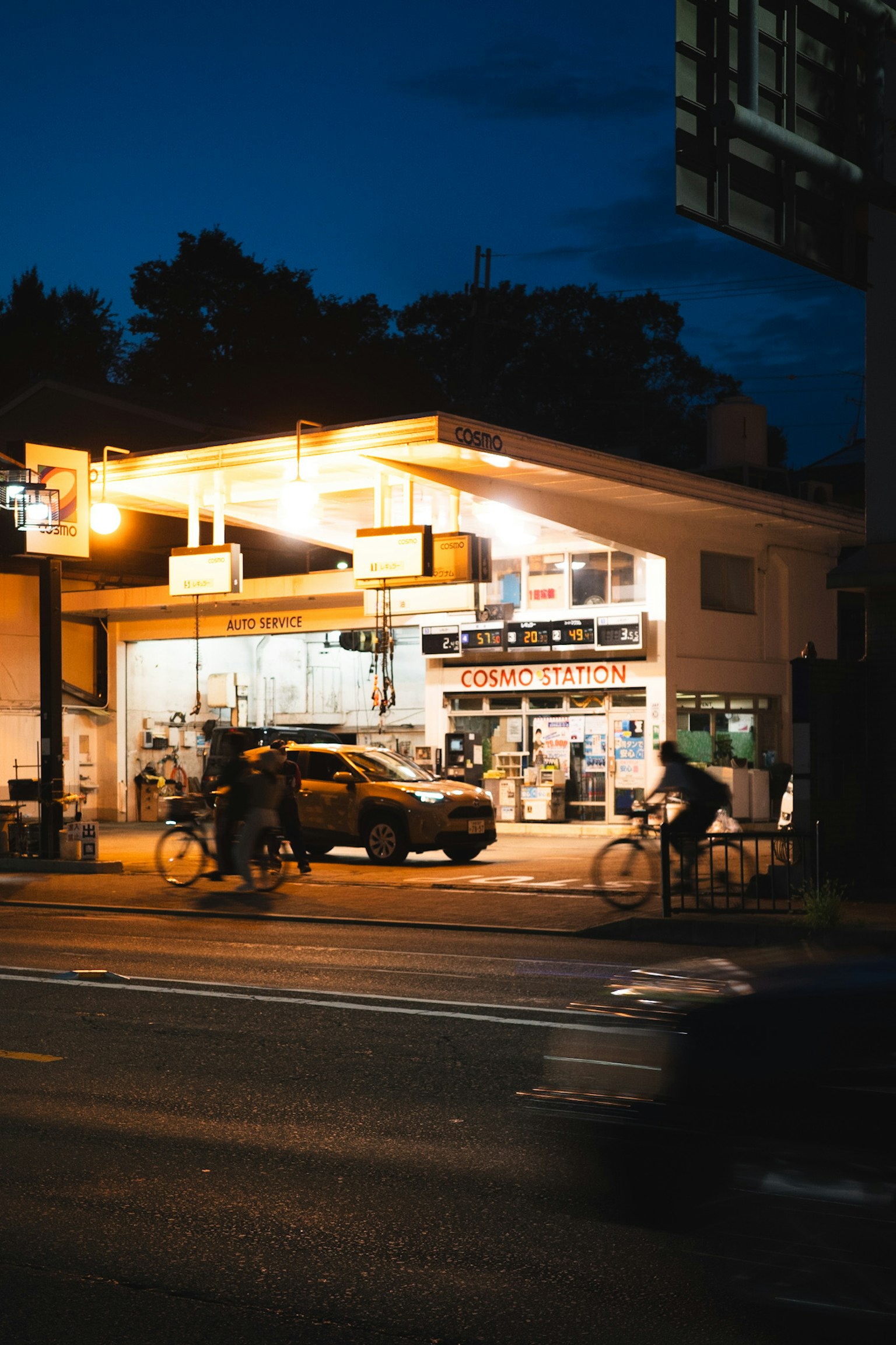 Bright convenience store on a street corner at night with pedestrians