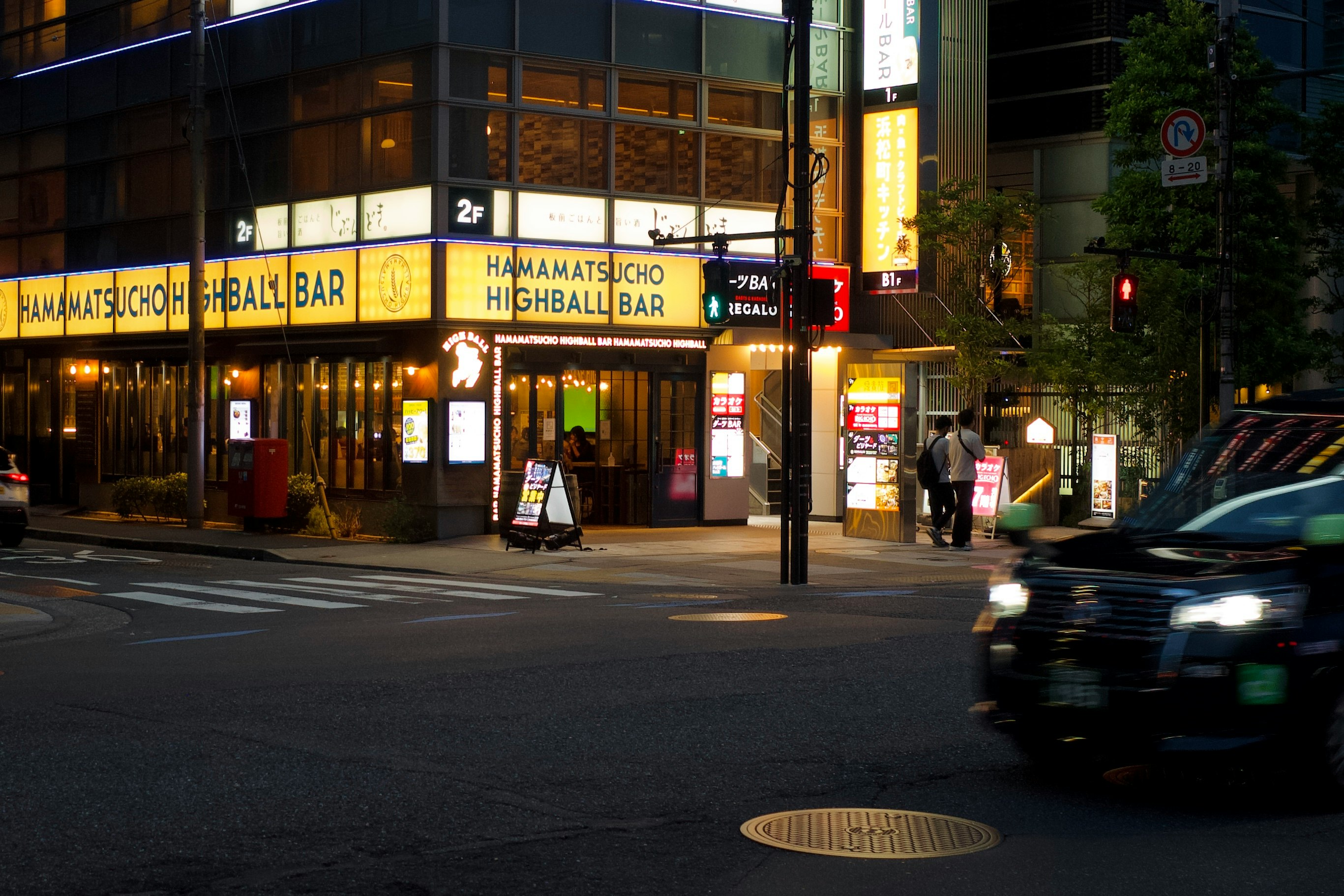 夜の交差点で看板が並ぶ居酒屋通りの街角
