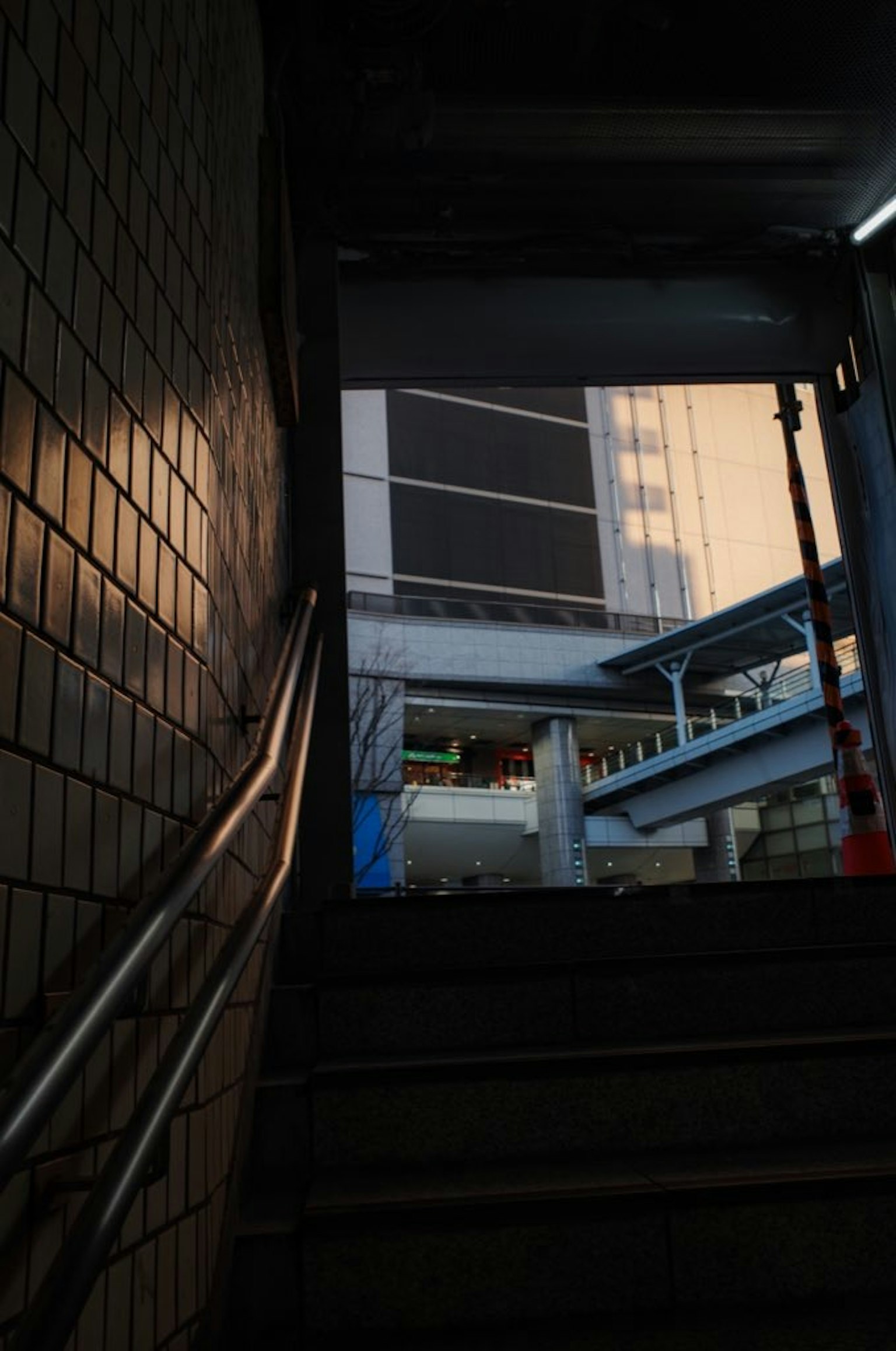 Vista desde el fondo de las escaleras mostrando un edificio y un pasamanos