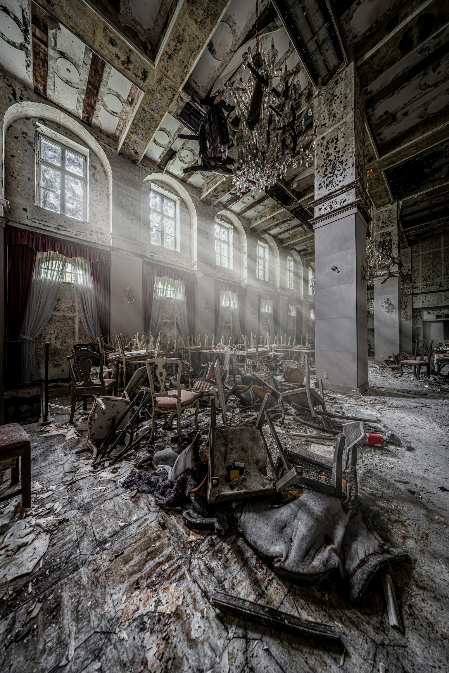 廃墟の中の暗い部屋に差し込む光と散乱した家具