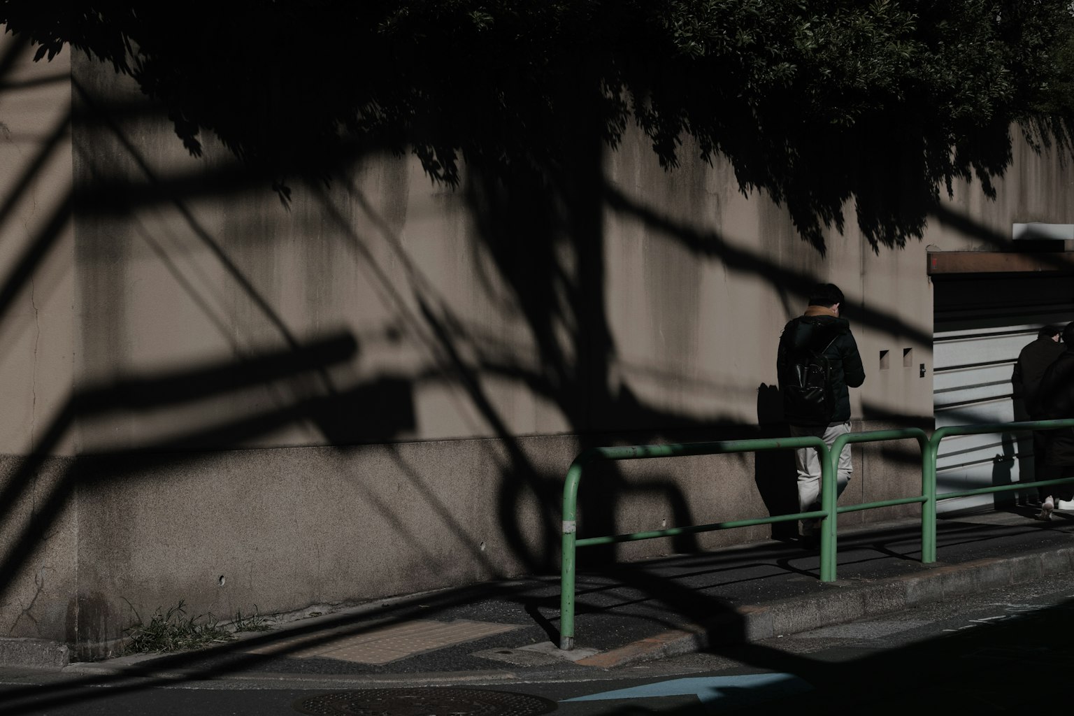 Scène urbaine avec des ombres projetées sur un mur deux personnes debout