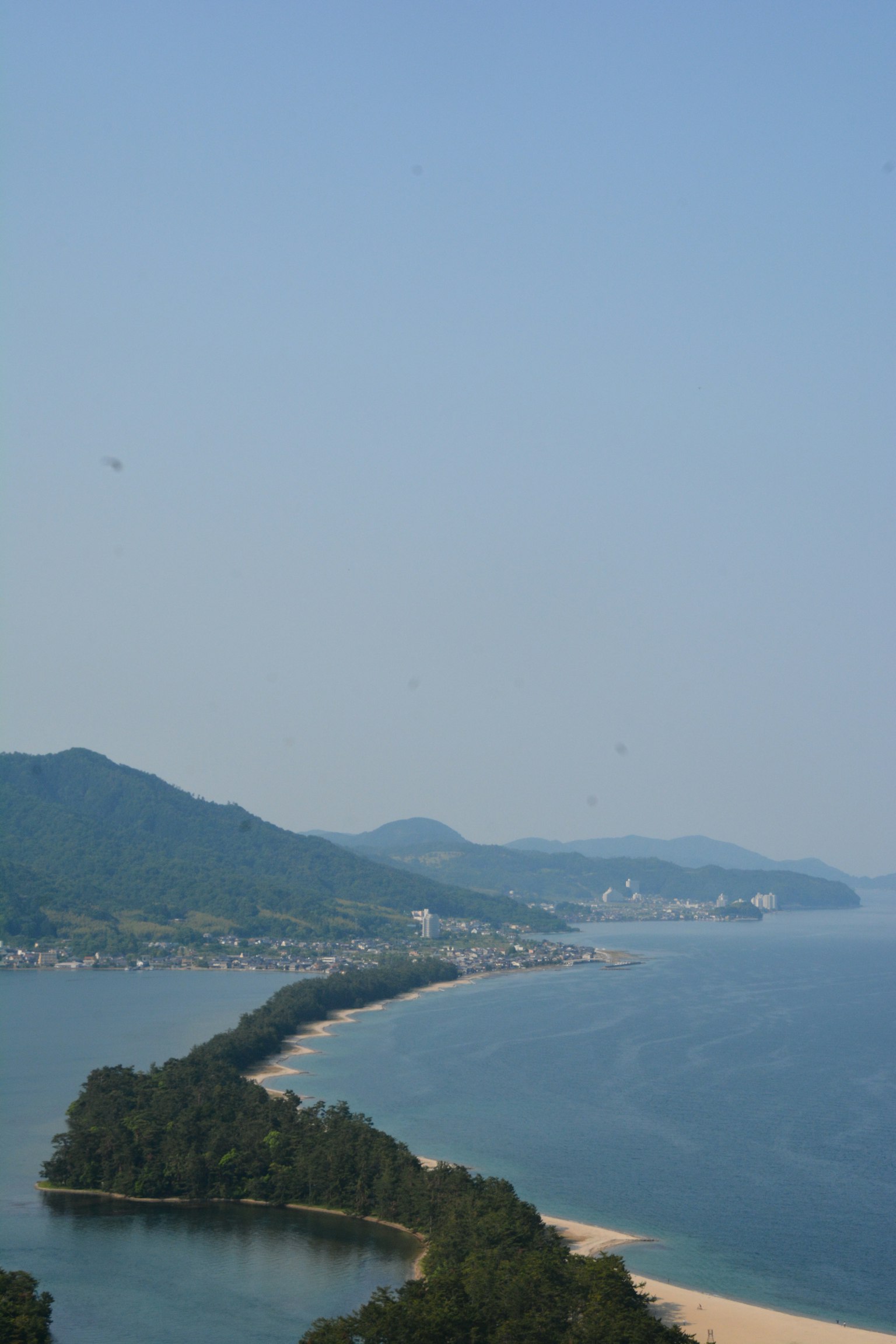 Pemandangan indah laut biru dan pegunungan dengan pantai pasir dan pohon hijau