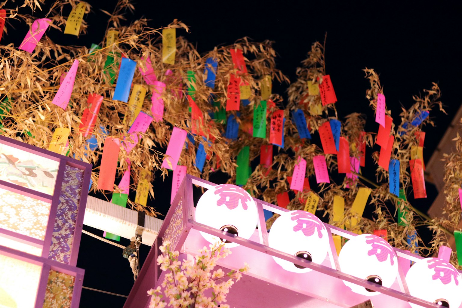 五彩紙條懸掛在竹枝上，背景是夜空