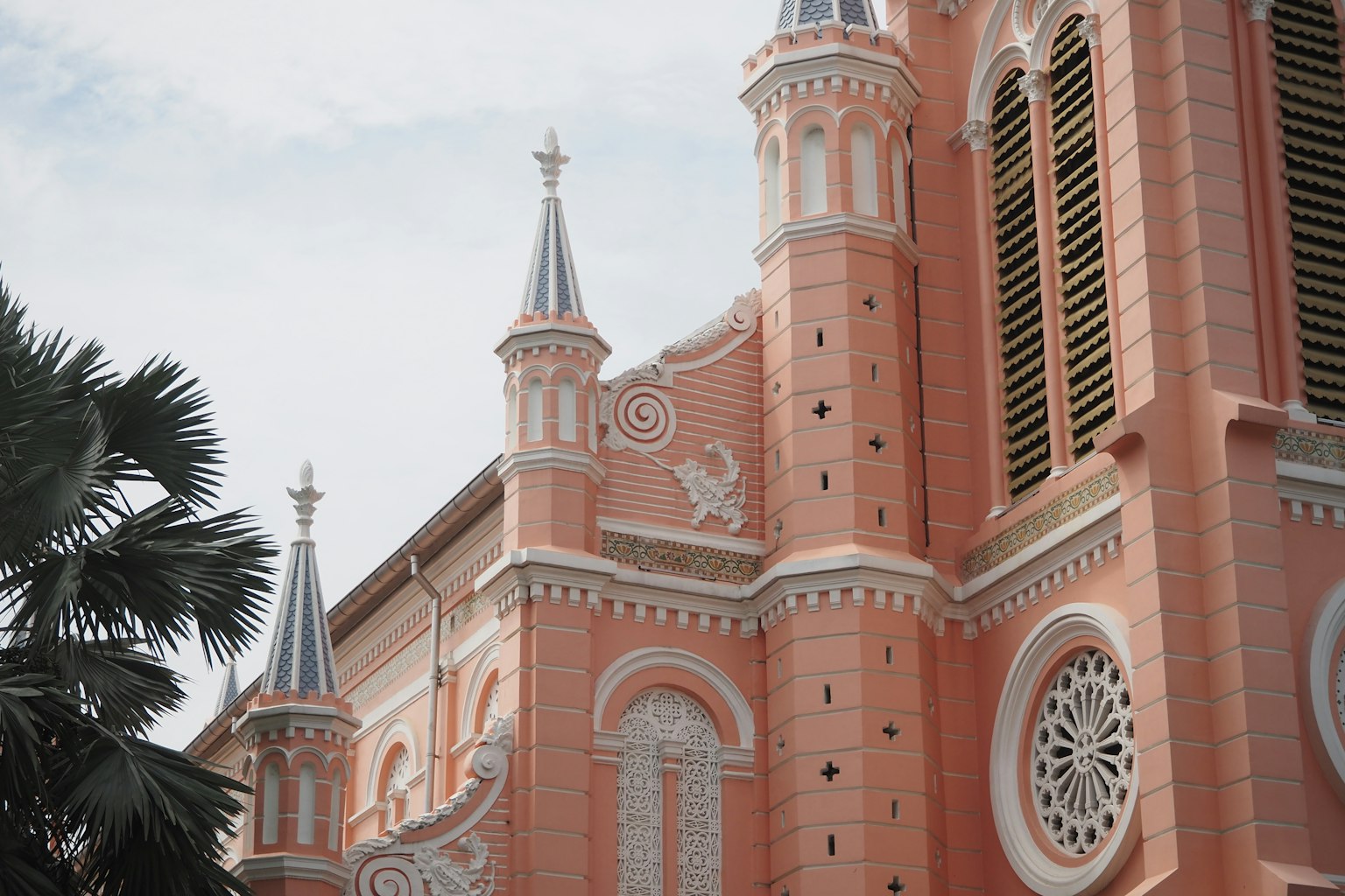 Vista dettagliata dell'esterno di una chiesa rosa con guglie