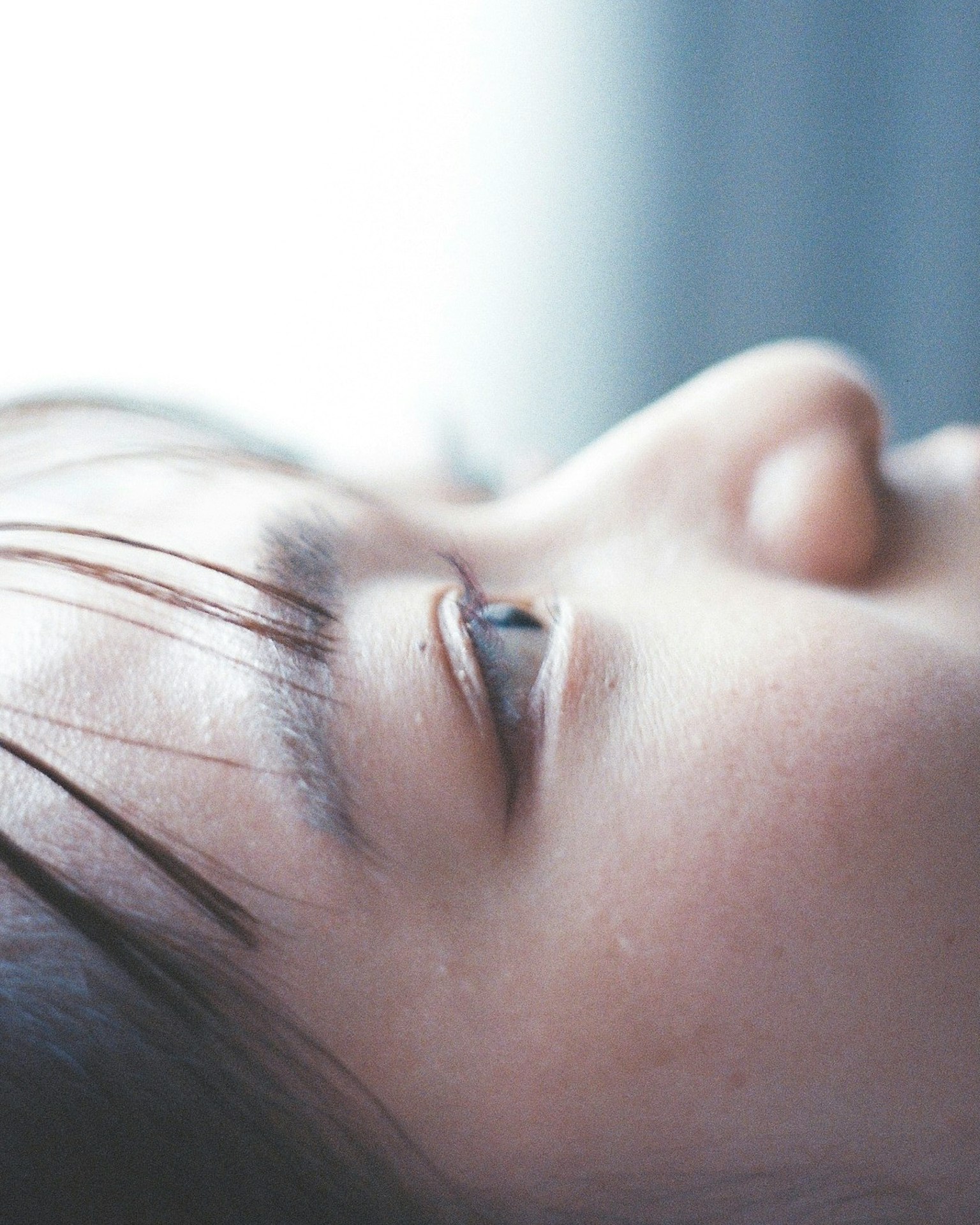 Close-up of a woman's profile with closed eyes highlighting delicate eyelashes and skin texture