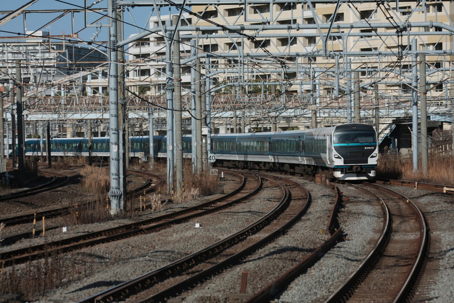Treno che percorre binari curvi in un'area industriale con edifici circostanti