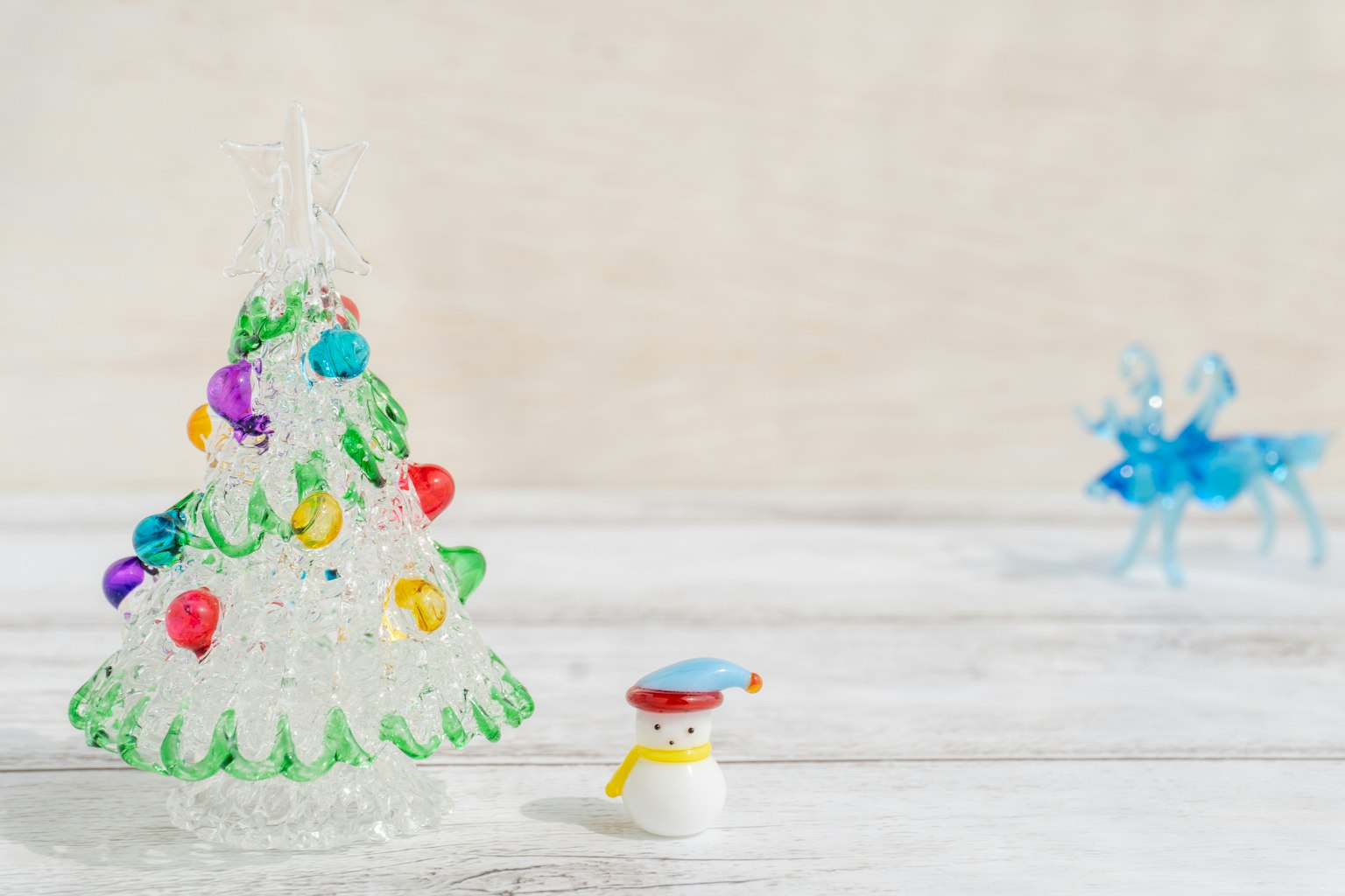 Pohon Natal transparan dekoratif dengan lampu berwarna dan patung manusia salju
