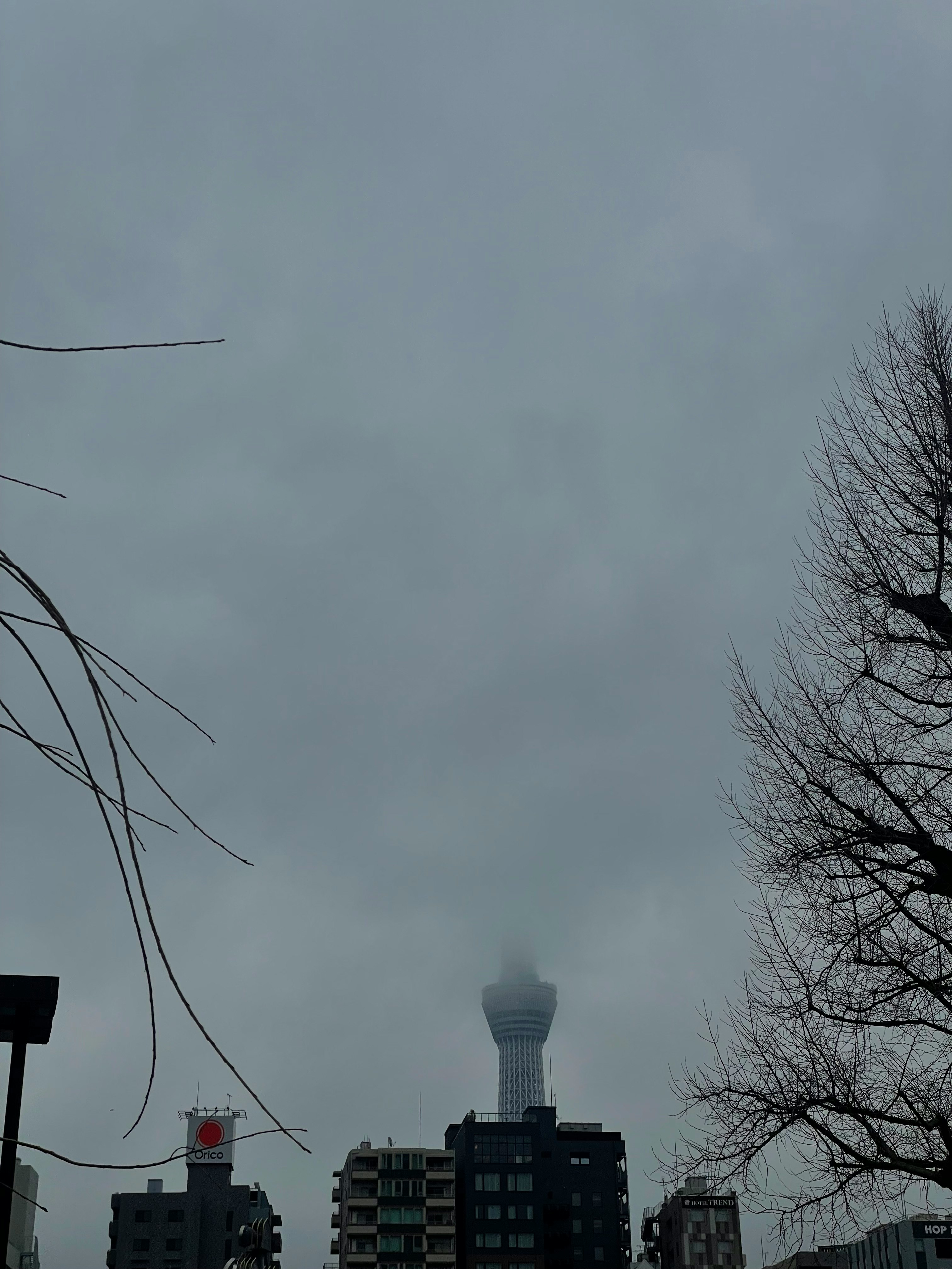 曇天の空と高層ビル、煙突のある建物