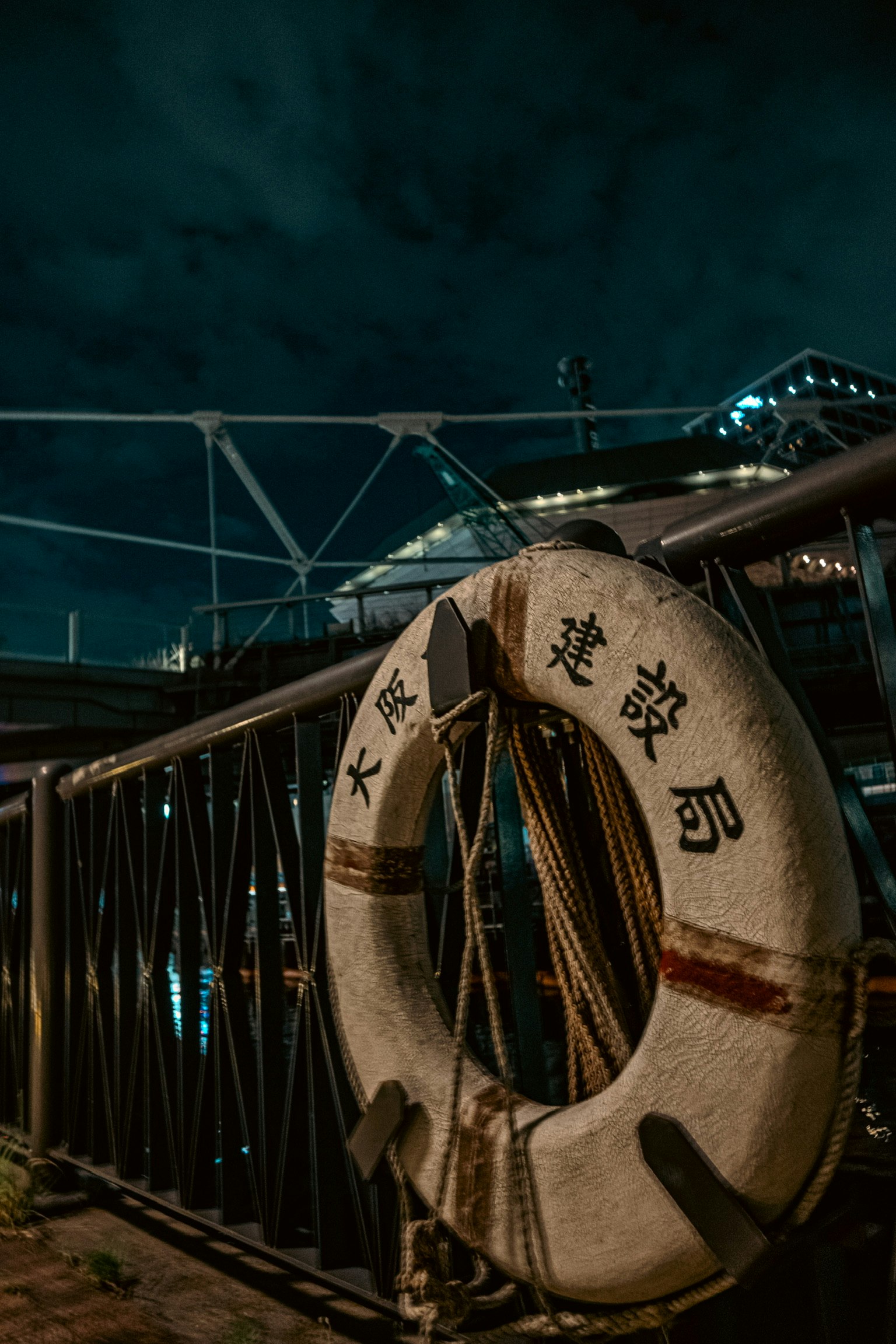 Boya en un muelle con una barandilla de metal de noche