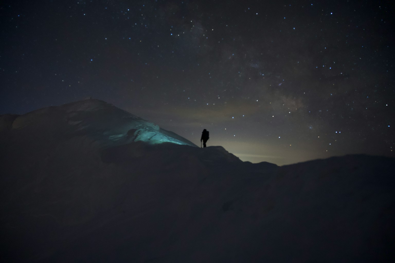 在星空下，雪山上站着的人影
