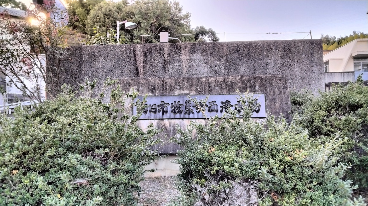 Insegna d'ingresso della Biblioteca della città di Ishigaki circondata da piante verdi