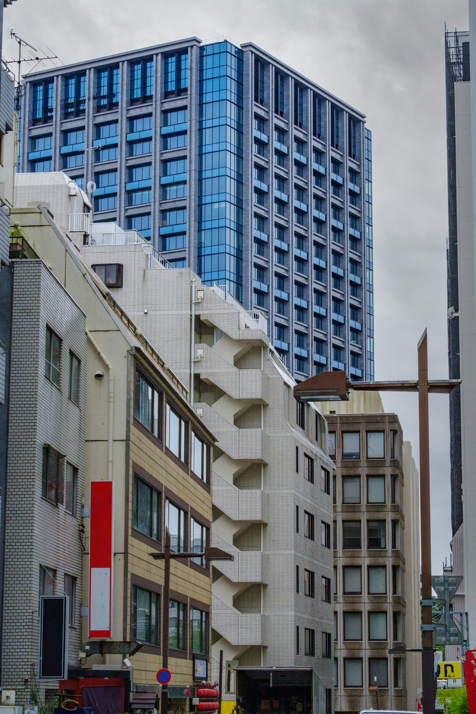 Modern high-rise building beside older architecture in urban setting